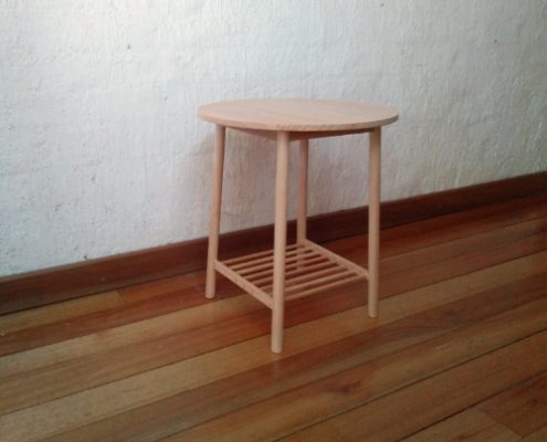 Wooden side table with a round top, round section legs and a shelf made from dowels