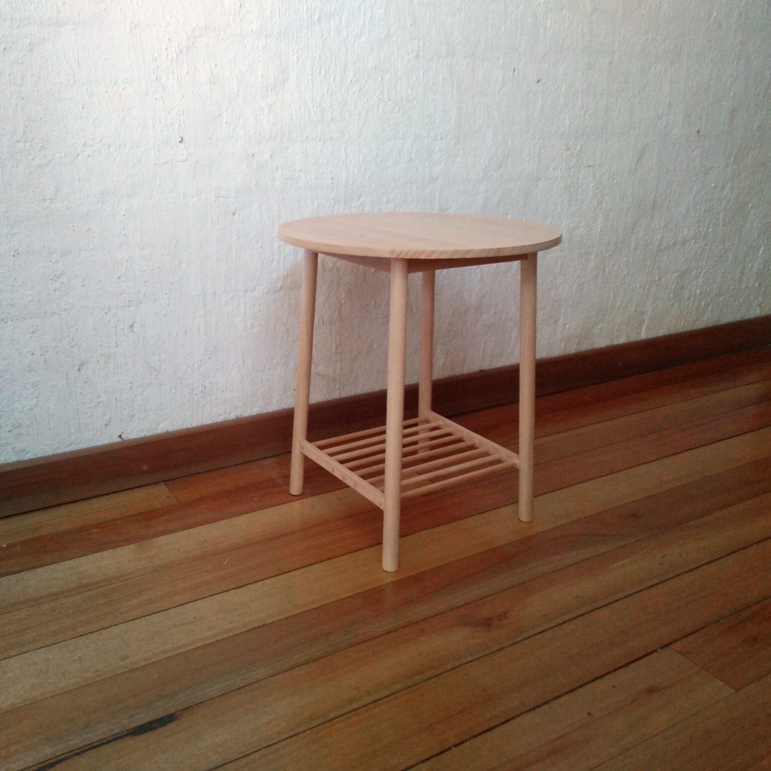 Wooden side table with a round top, round section legs and a shelf made from dowels