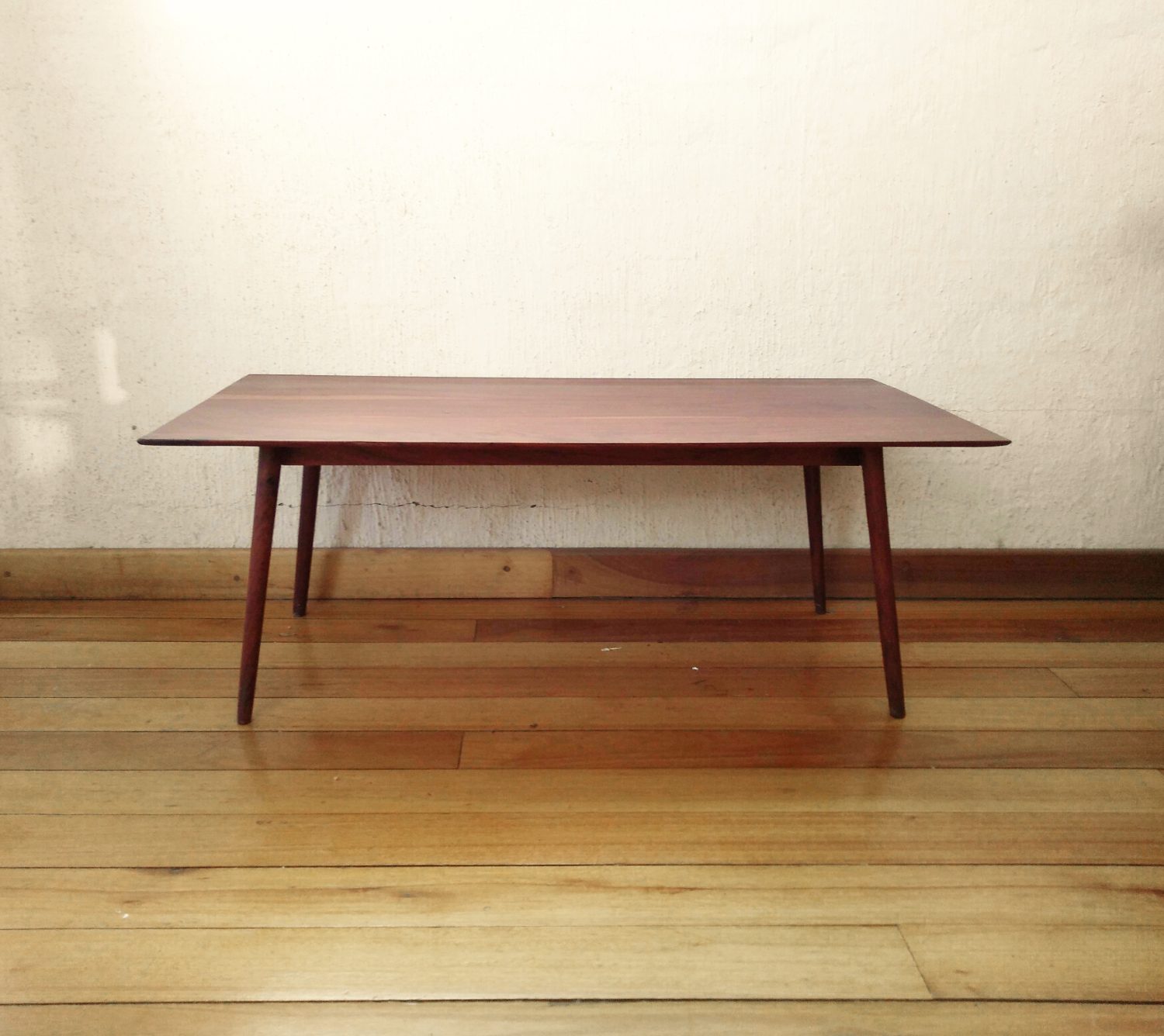 Delicate coffee table out of dark reddish timber with turned and tapered legs that splay out