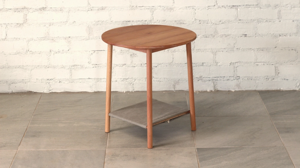Wooden side table round section legs round top blueish grey fabric shelf