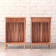 Front view of two bedside tables made from a warm pale brown timber with top drawer, open boxed storage space and slatted hardwood back panel.