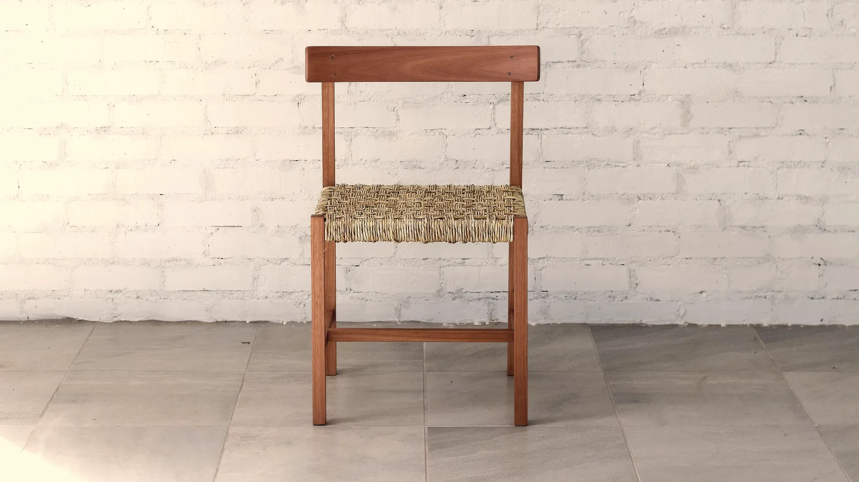 Chair Front Chair made from deep brown timber with a linear construction, natural ilala palm woven seat and a curved backrest.
