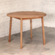 Round table with round section gently splayed legs made from a pale brown timber.