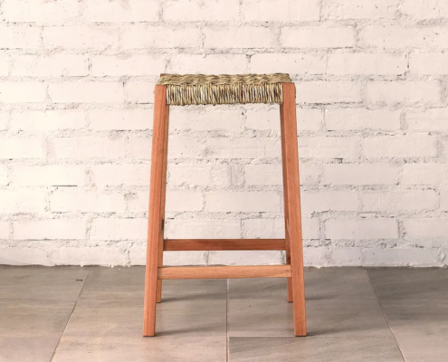 Stool made from a warm timber with gently splayed square section legs and a natural ilala palm woven seat.