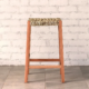 Stool made from a warm timber with gently splayed square section legs and a natural ilala palm woven seat.