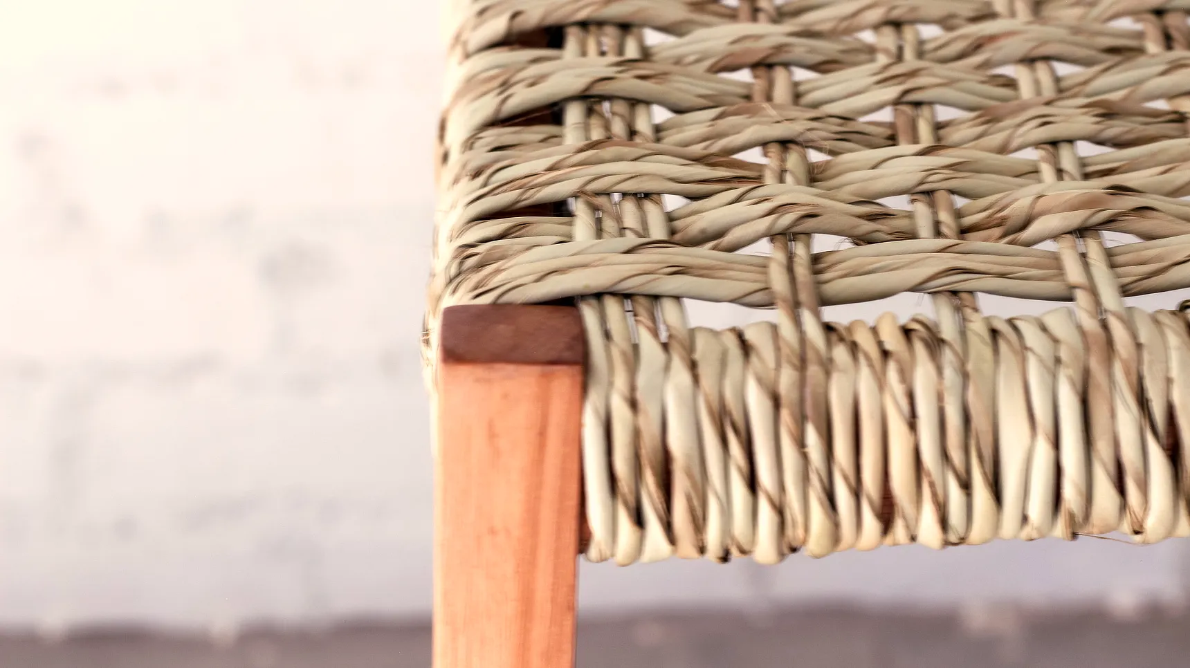 Detail of wooden stool with woven ilala palm seat.