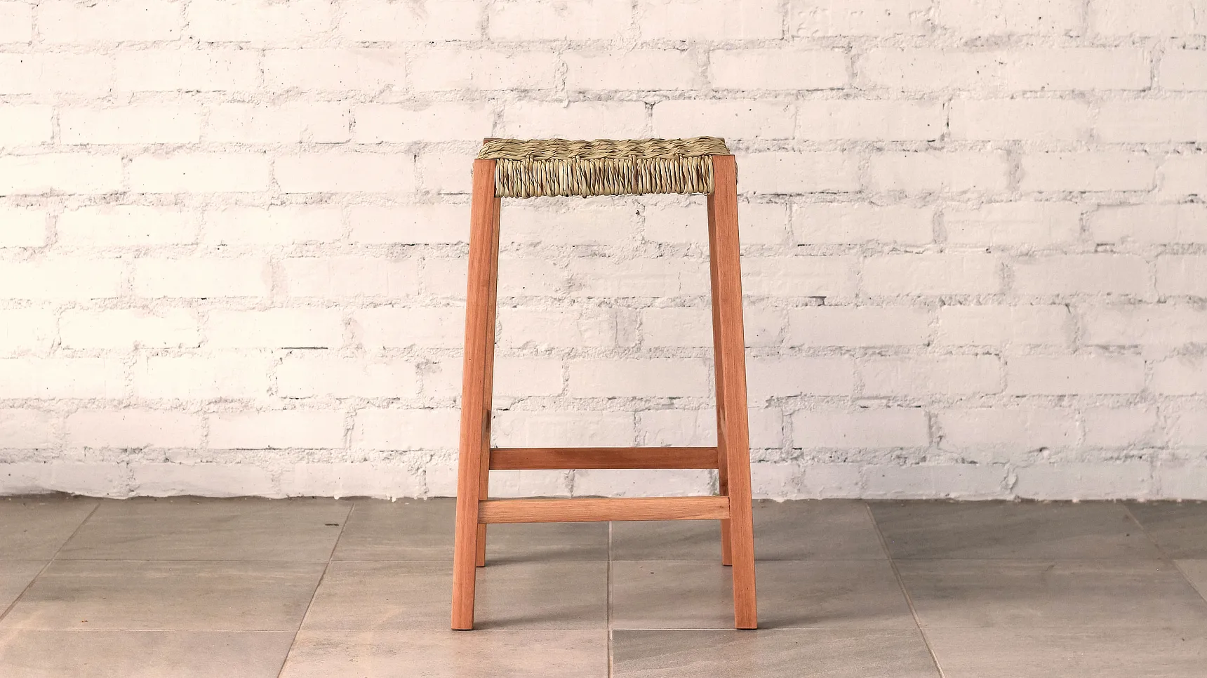 Wooden stool with woven ilala palm seat and square section gently splayed legs.