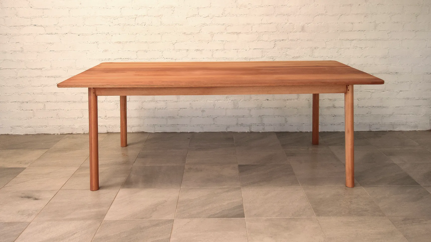 Table made from a warm, pale brown timber with round section legs that gently splay out.