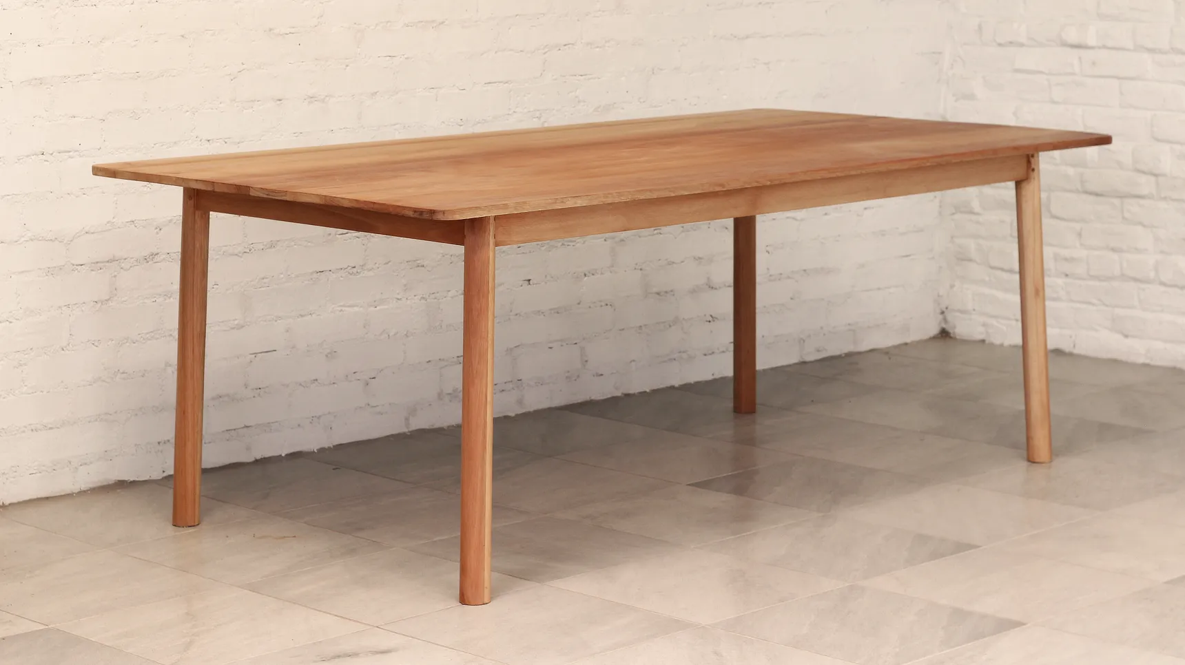 Table made from a warm pale brown timber with gently splayed round section legs.