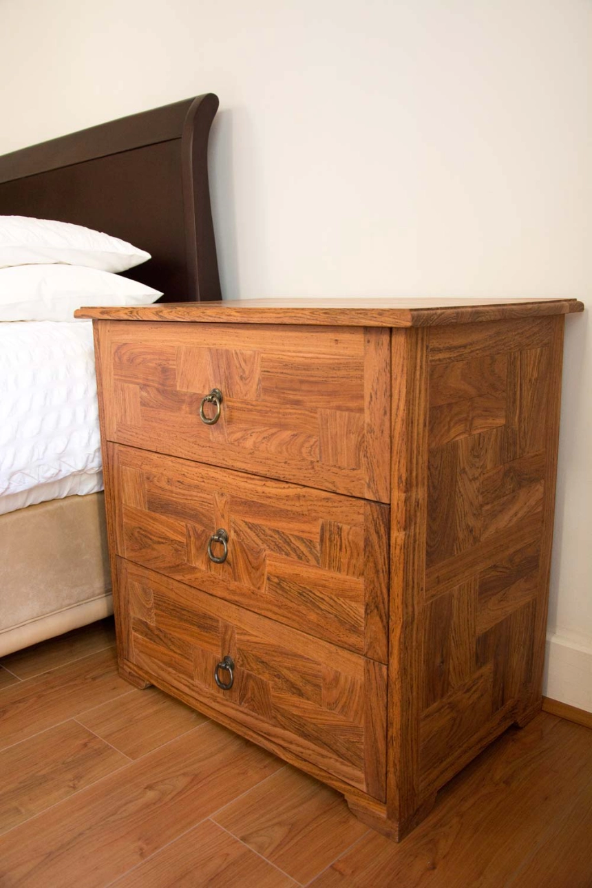 A bedside table made from teak tiles with alternating grain direction to form a pattern for the drawer fronts and side panels.