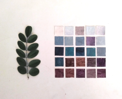 A photograph of a leaf on the left and a gridwork of small multi colored painted card tiles on the right.
